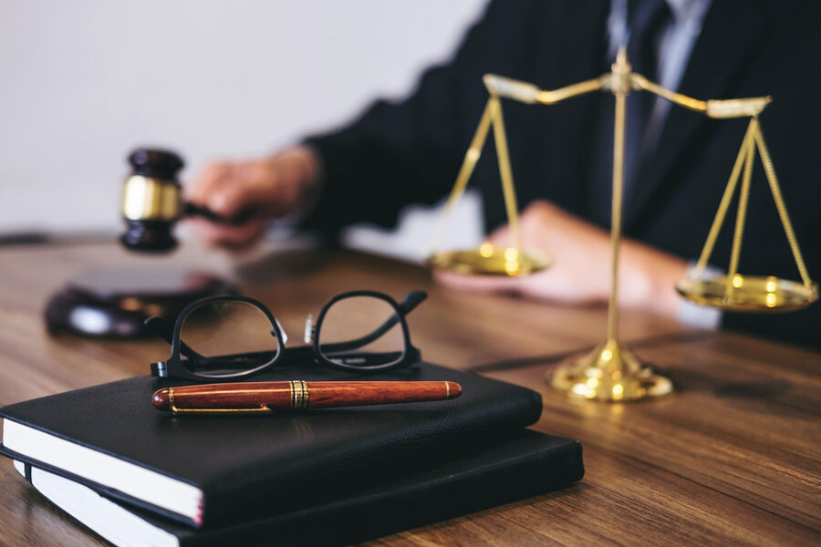 Attorney's desk with scales of justice, glasses and pen