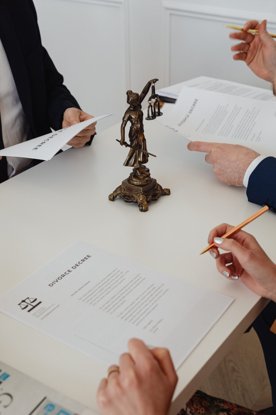 Signing legal documents with a Lady Justice statuette on the table