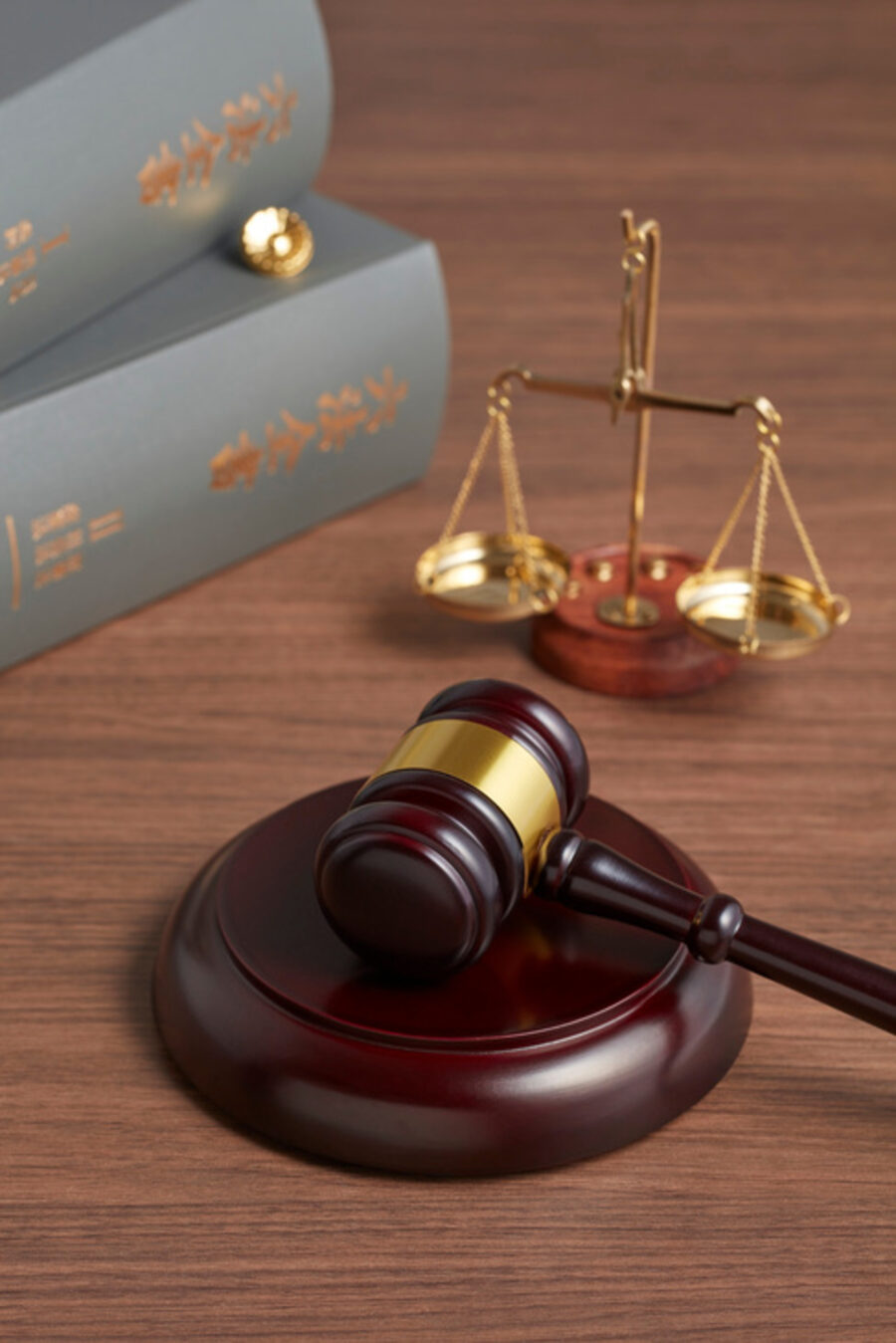 Gavel, sound block and scales of justice on a wooden desk